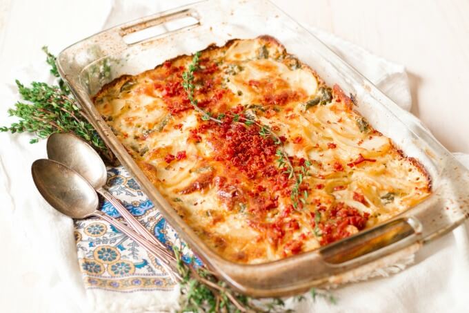 Scalloped potato casserole with bacon and thyme on top.