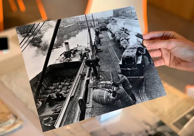 An archival photo of Guinness barges being loaded on the River Liffey.