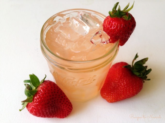 Strawberry Ginger Switchel served over ice with fresh strawberries.