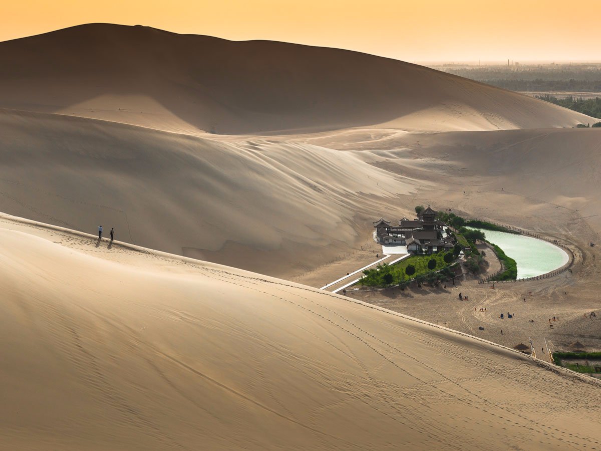 the-crescent-lake-or-yueyaquan-in-chinese-is-a-fresh-water-spring-in-the-shape-of-a-half-moon-that-sits-in-the-gobi-desert-the-oasis-is-believed-to-have-existed-for-around-2000-years-though-it-has-seen-its-water-levels-decline-and-attractio