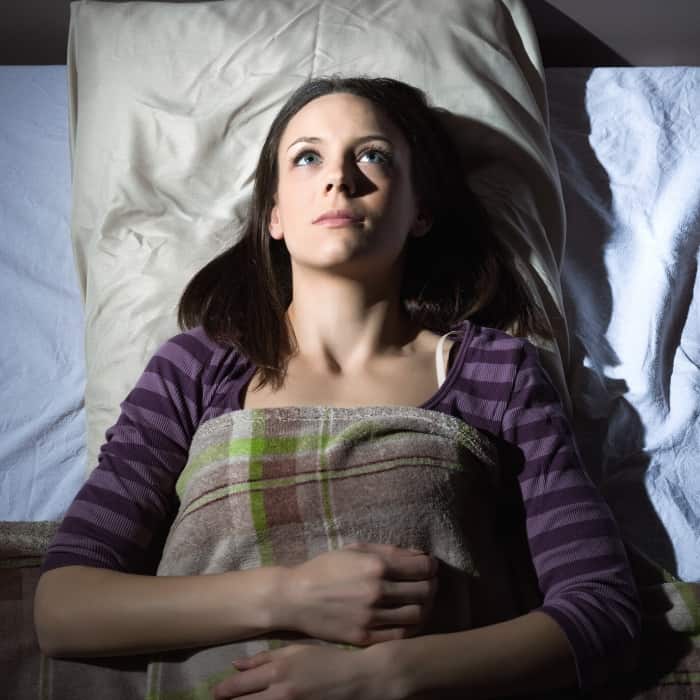 woman waking up in bed after an intense dream