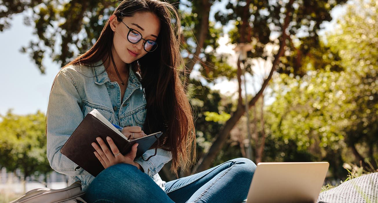 A girl studying outside near her college campus