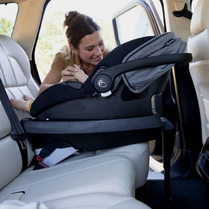 woman looking at baby in her car seat