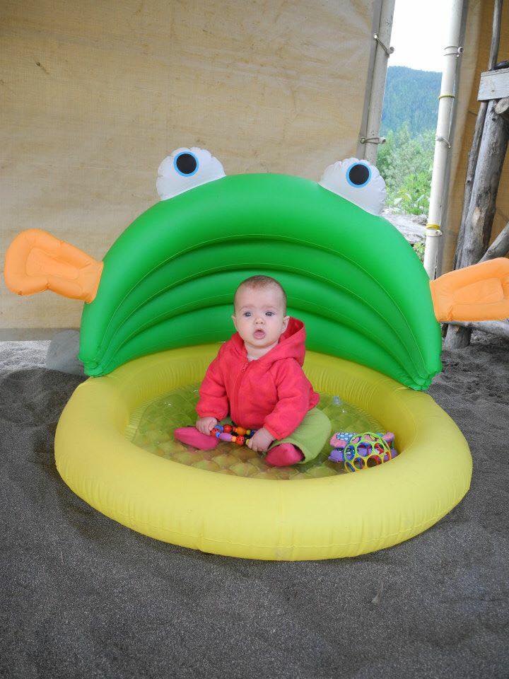 Camping baby in an inflatable infant pool as a playard