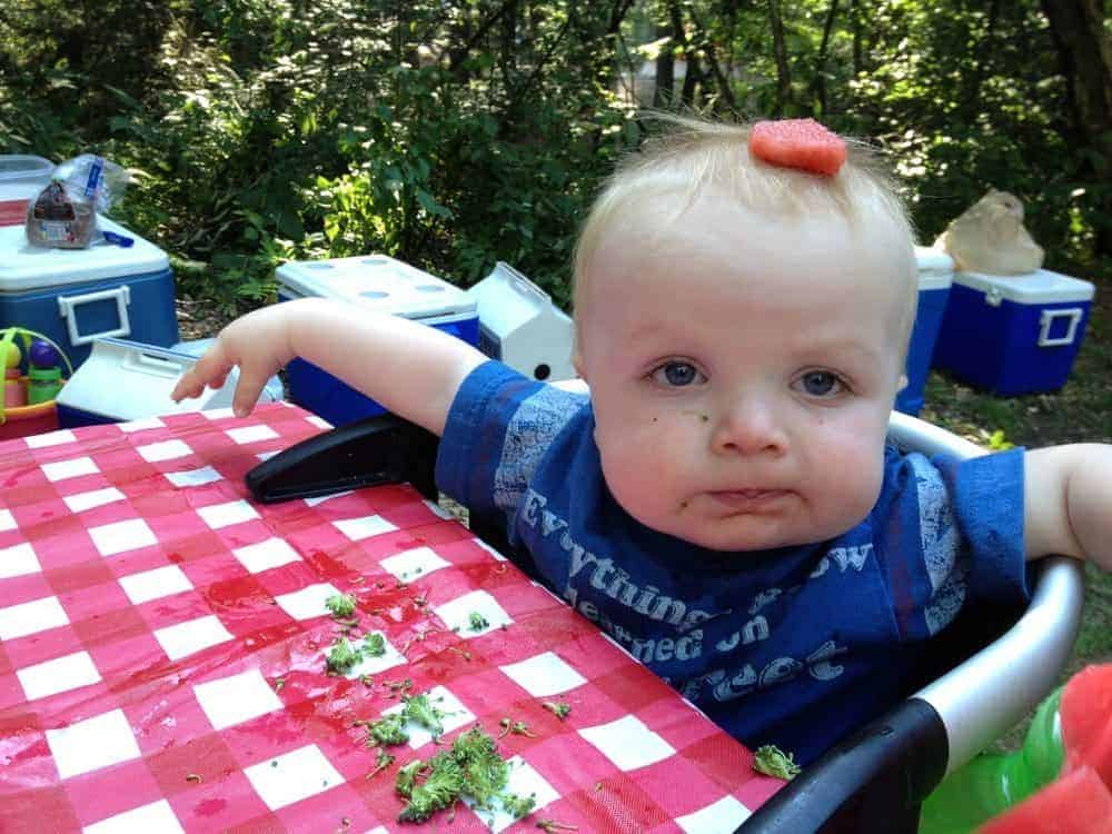 baby in clip on high chair