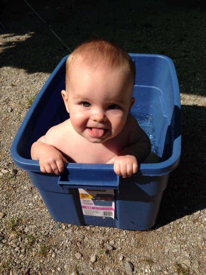 baby having a bath in a storage container