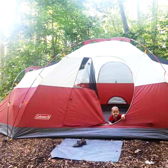 camping baby sitting in a tent