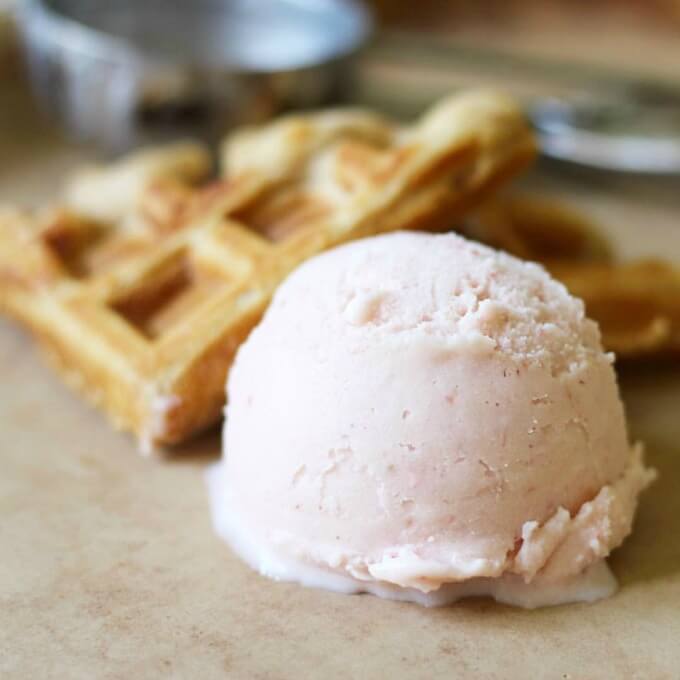 Scoop of watermelon ice cream with homemade waffles.