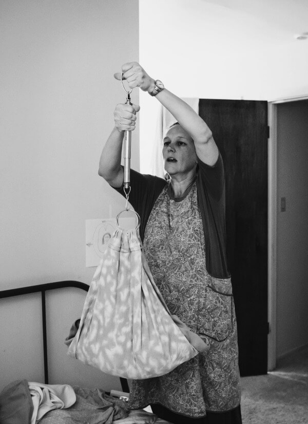 Newborn baby being weighed during his newborn exam at home by his midwife after his home birth.