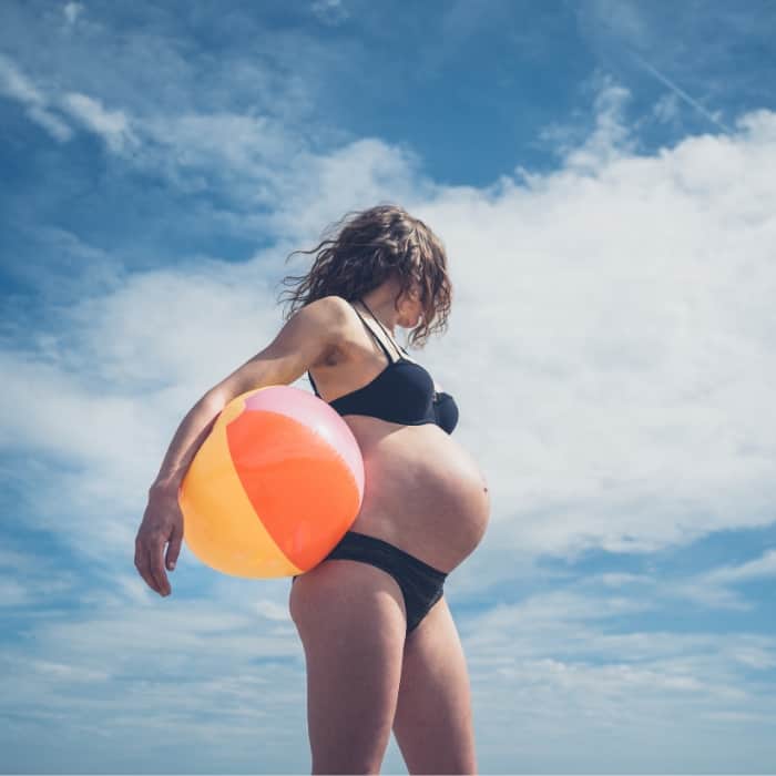 pregnant woman at the beach in a bikini